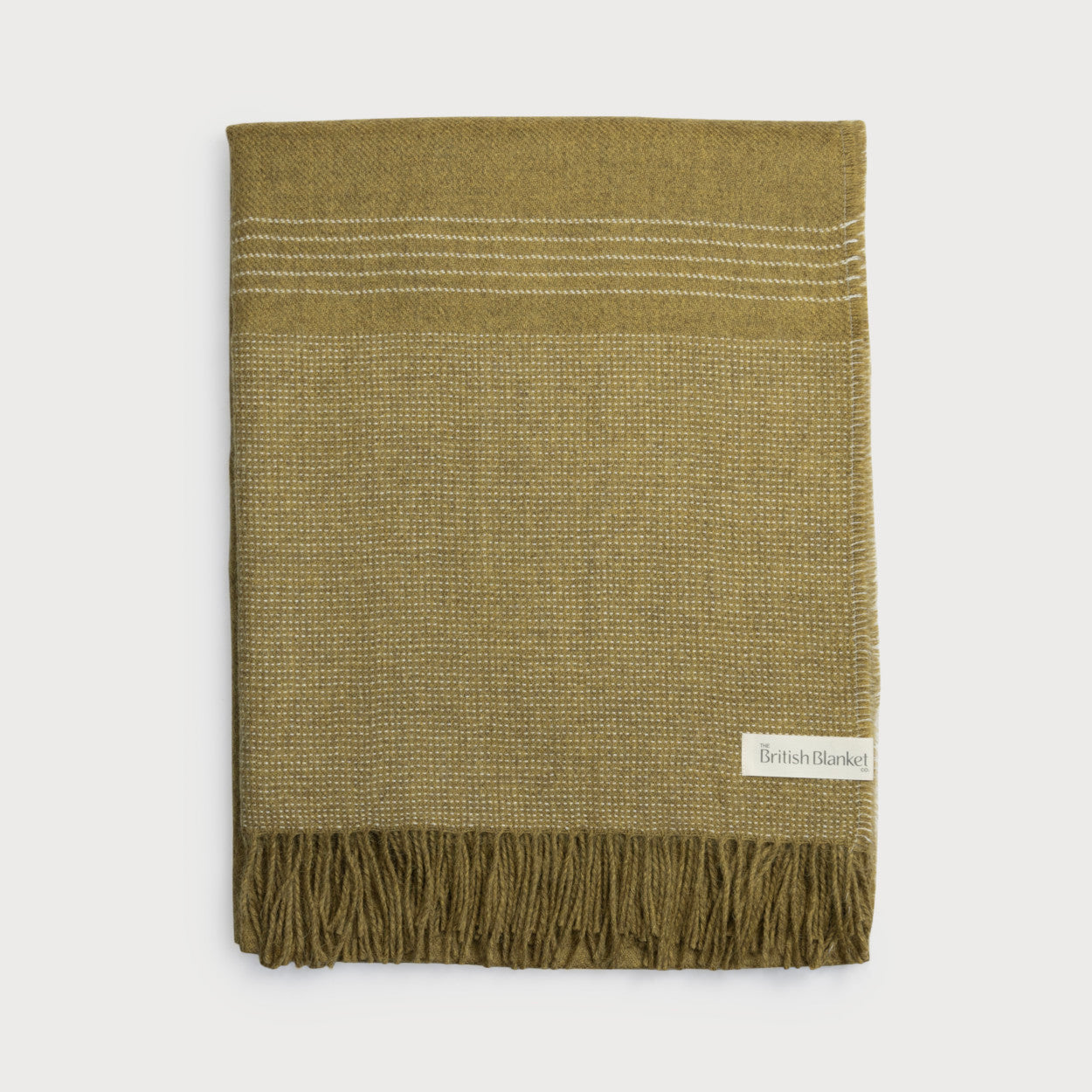Folded olive-green wool throw with dotted weave and white stripes, fringed ends, labeled “British Blanket,” part of the Alpaca Blanket Gift Box: Golden Moss.