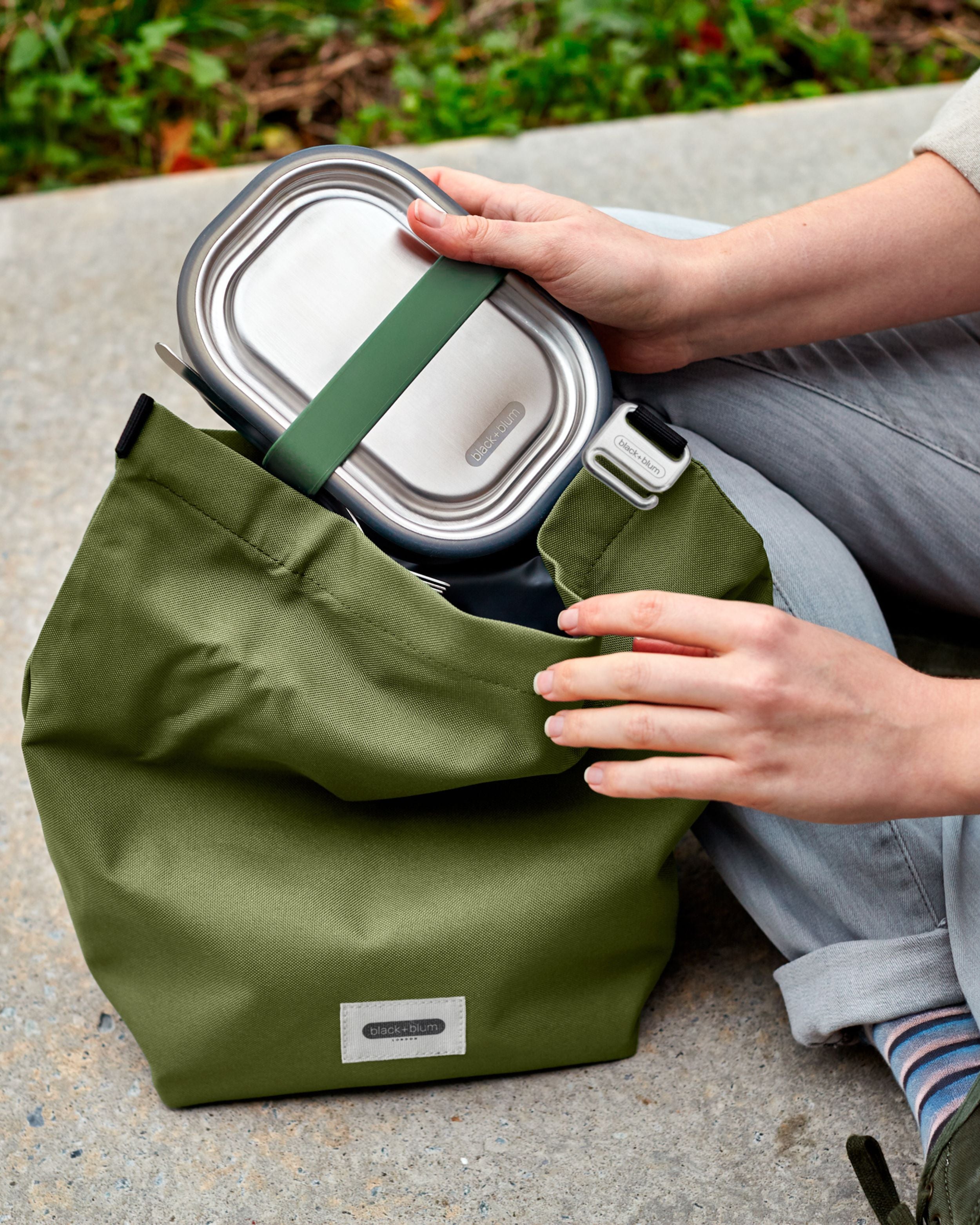 Person using the Black + Blum lunch bag and box