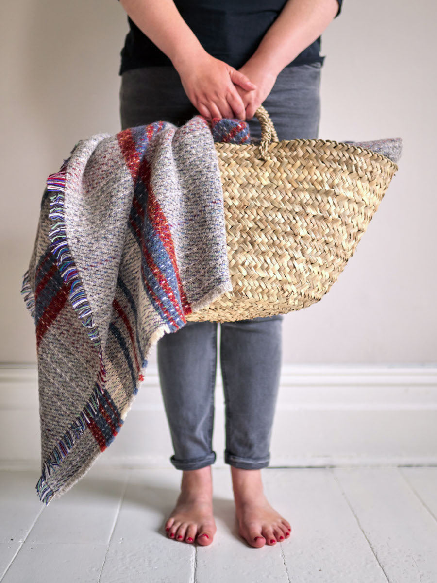 woman with basket of random recycled rugs from The British Blanket Company