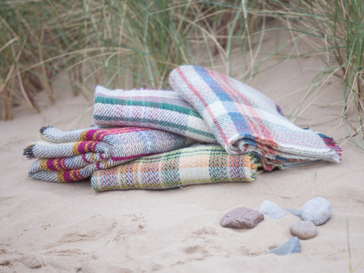 on the beach stack of Random recycled wool throw blanket - The British Blanket Company