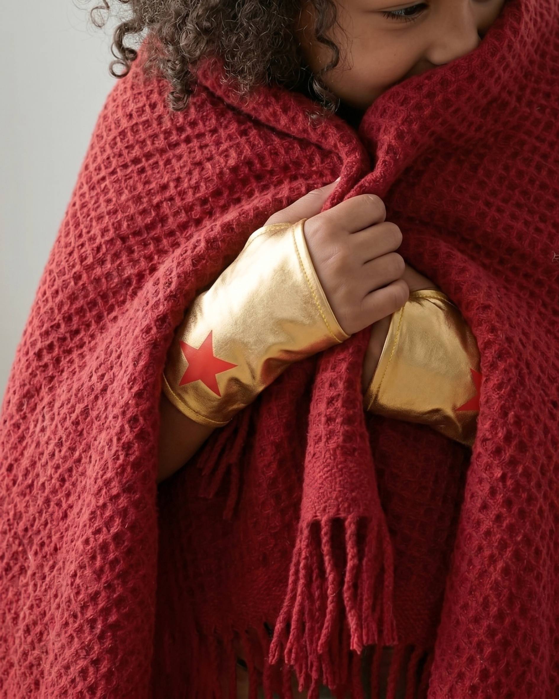 A close up image of child playing with Red Waffle kids blanket