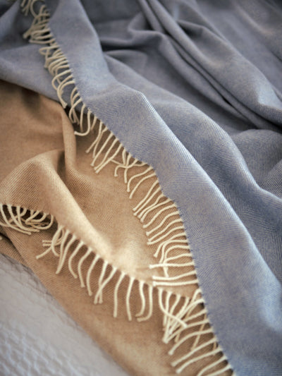 blue and beige wool blankets on a bed