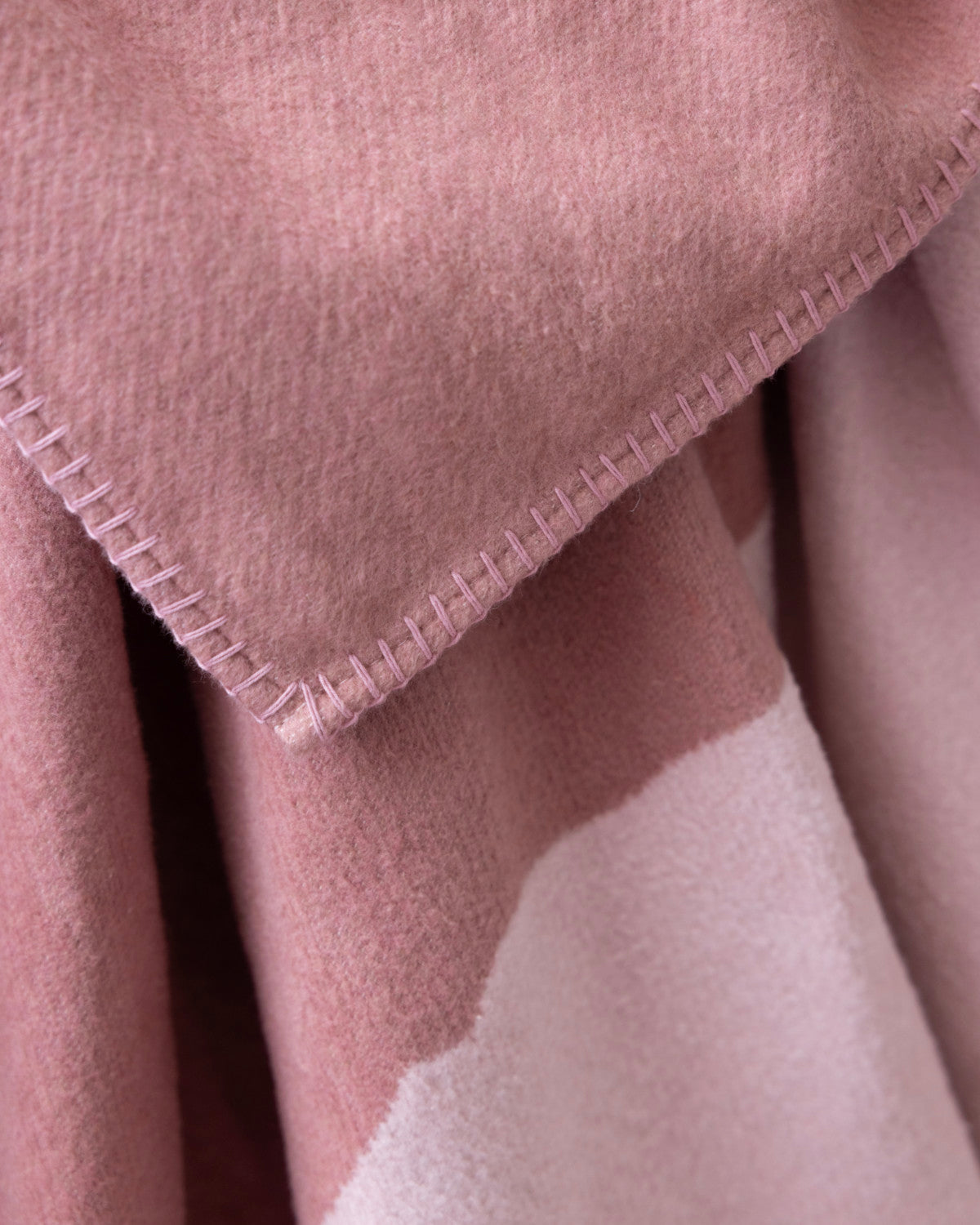 Cloud Cotton Blanket: Vale in Blush, featuring a two-tone pink design with darker dusty rose and pale pink, whip-stitched edges, and a soft, fleece-like texture.