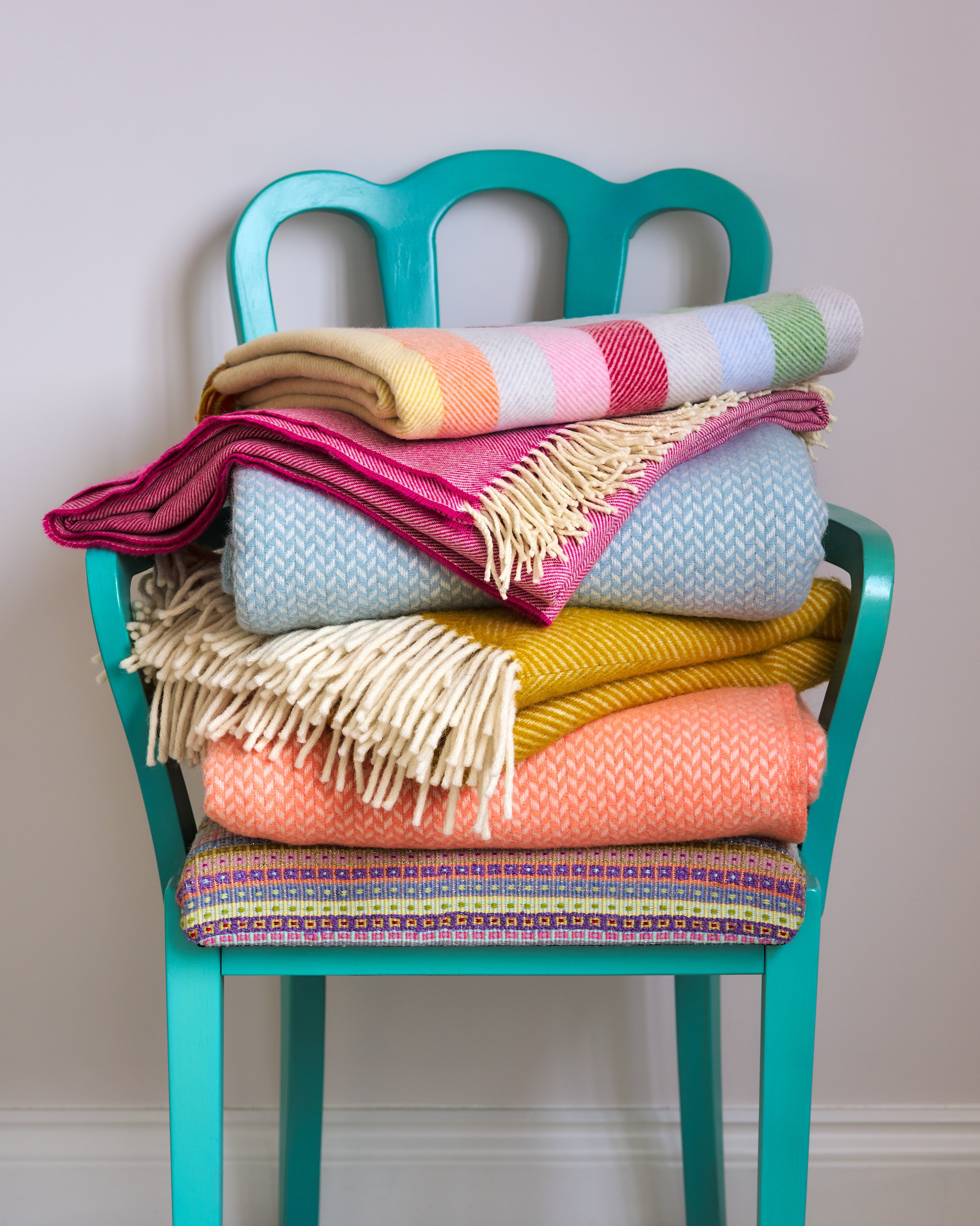 Stack of Wool Blankets on a chair from The British Blanket Company