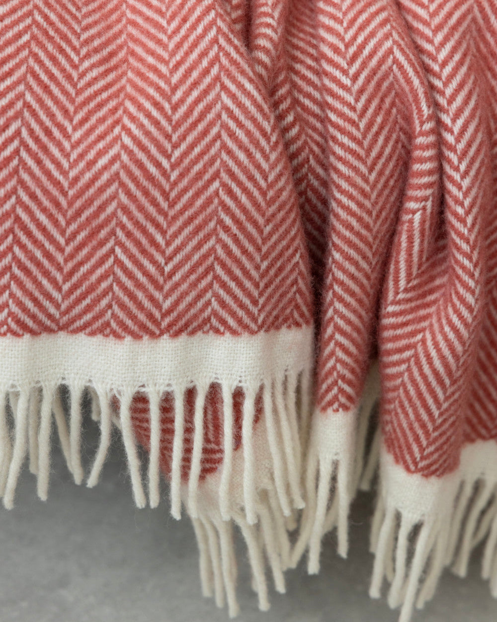 Clifton Blanket Gift Box: Rose, featuring a folded wool herringbone blanket with white fringe, perfect for gifting with chocolate and candle in a colorful box.