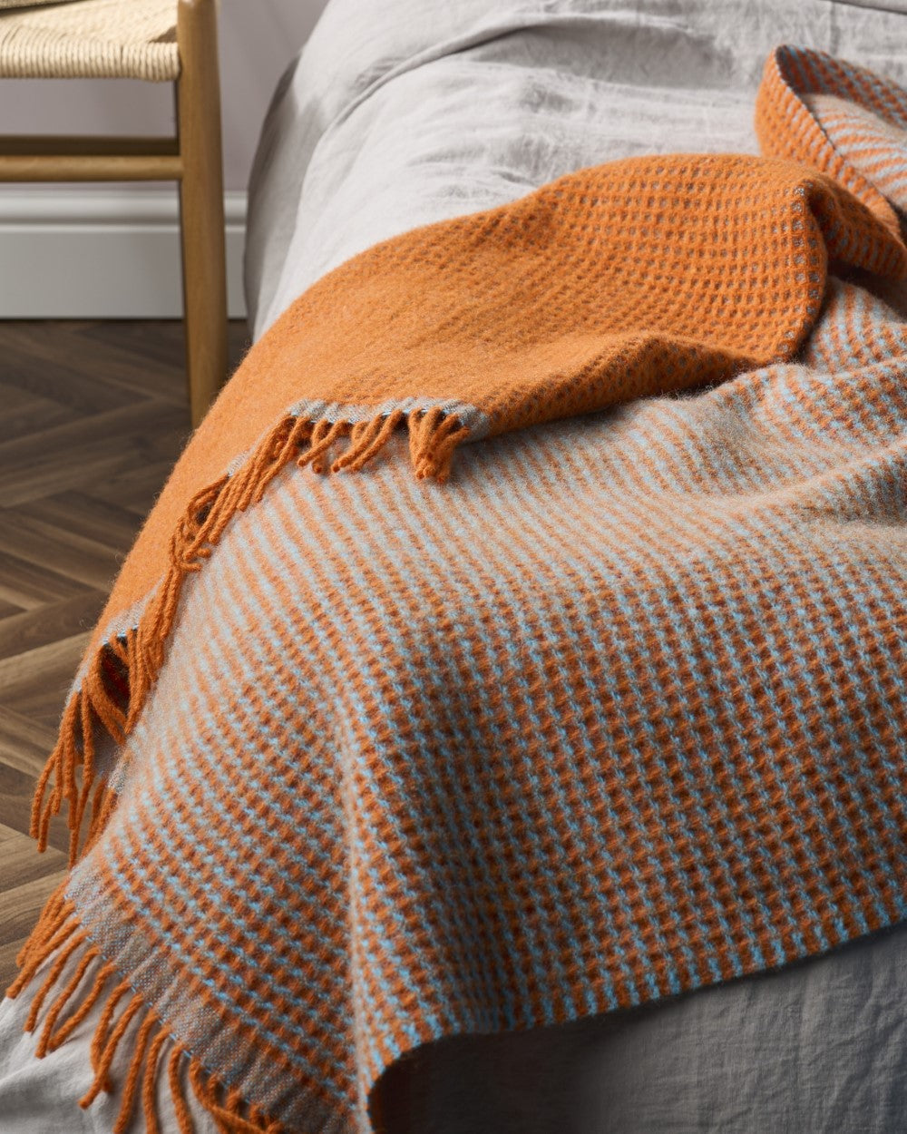Totterdown Waffle Blanket: Beacon & Lido, woven from pure sheep's wool, displayed on a bed showcasing its reversible, textured waffle weave design.