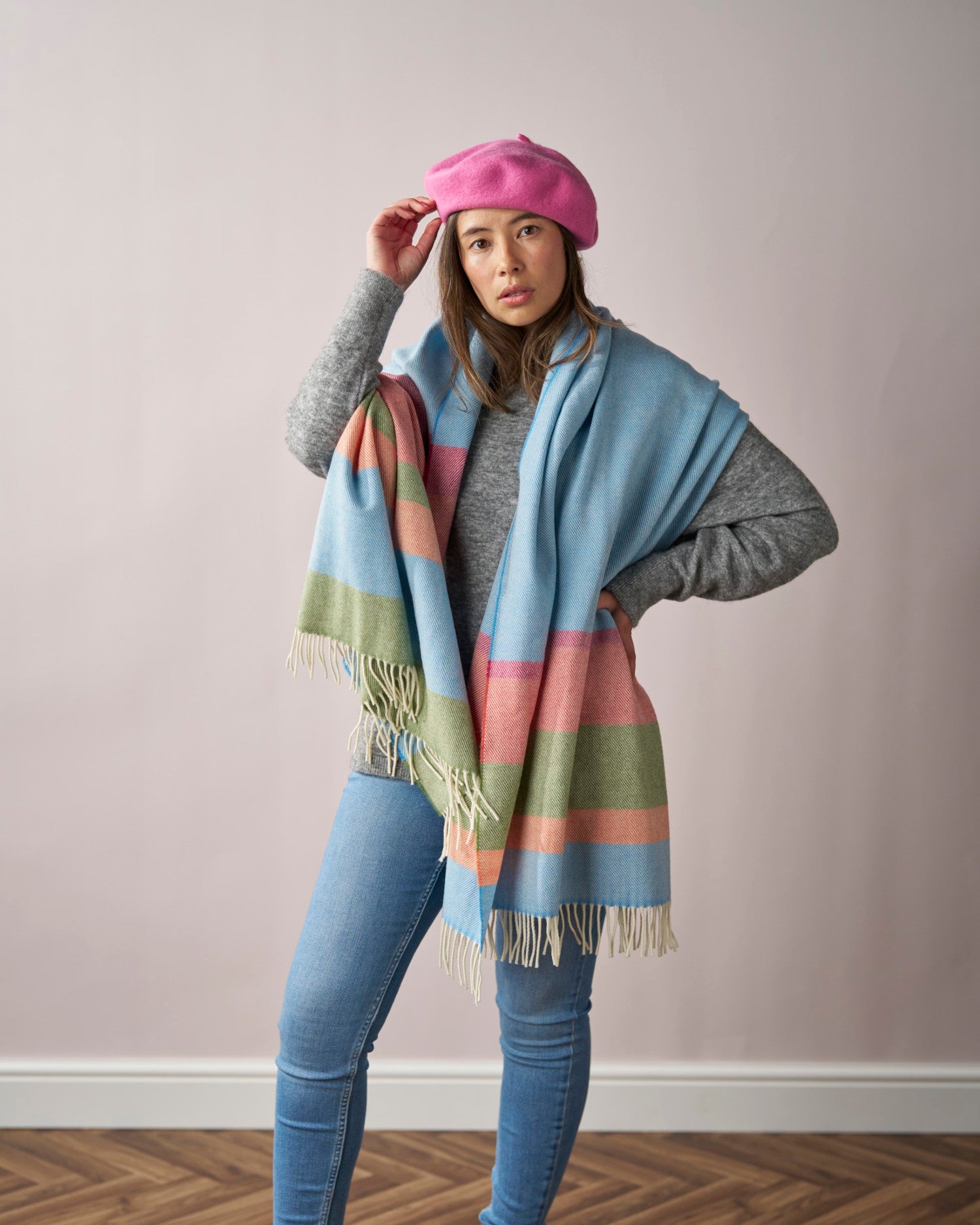 Woman in a soft pink Wool Beret Hat, touching it casually. The hat is thicker for durability and warmth, ideal for chic everyday wear.
