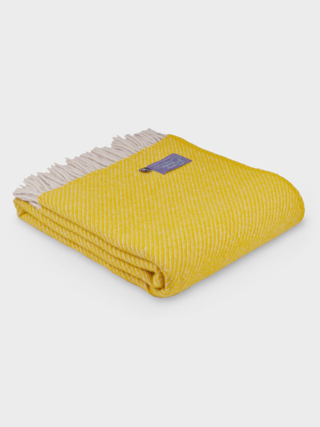 A folded yellow herringbone wool throw by The British Blanket Company.