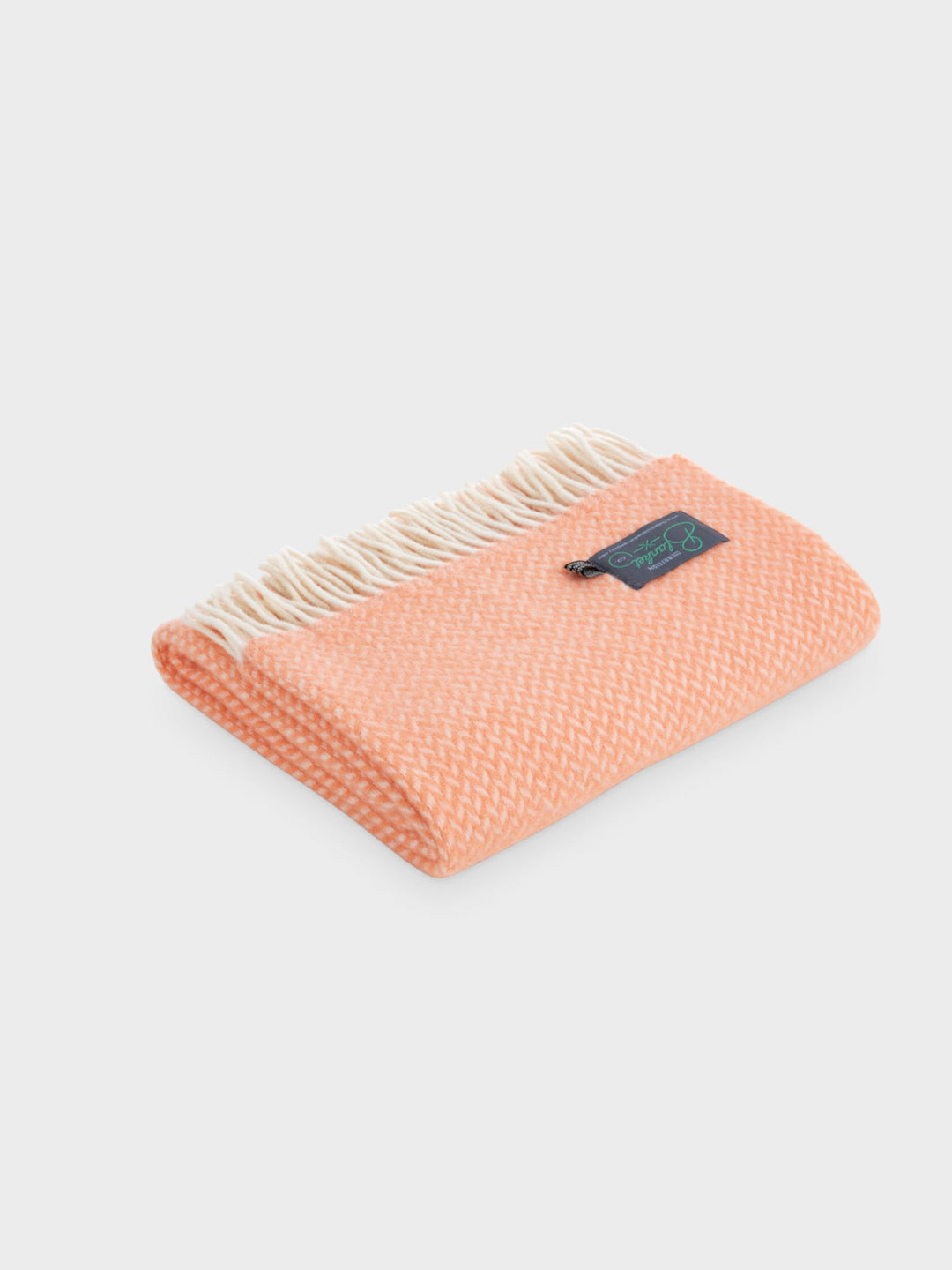 Folded bright orange herringbone wool throw by The British Blanket Company.