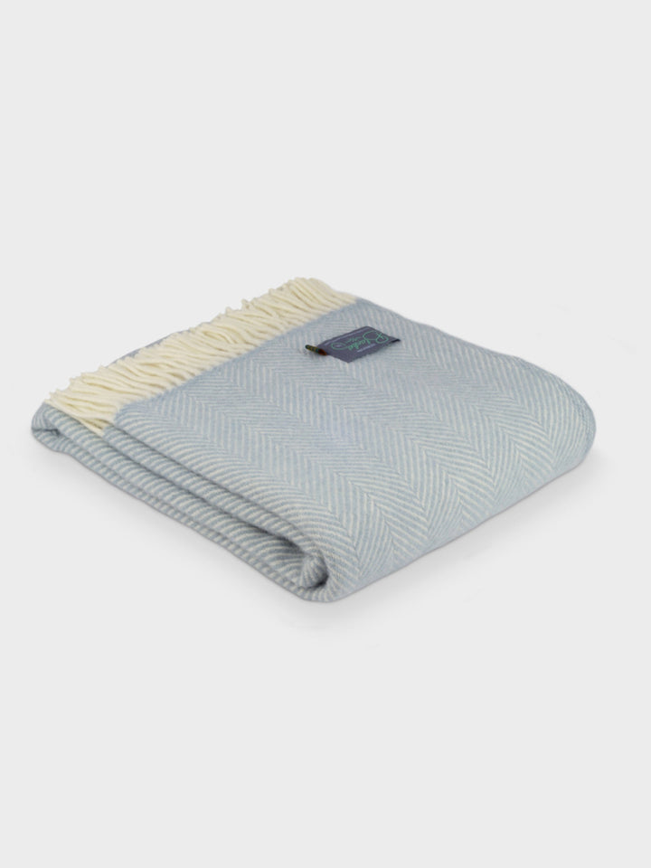 Folded blue herringbone wool blanket by The British Blanket Company.