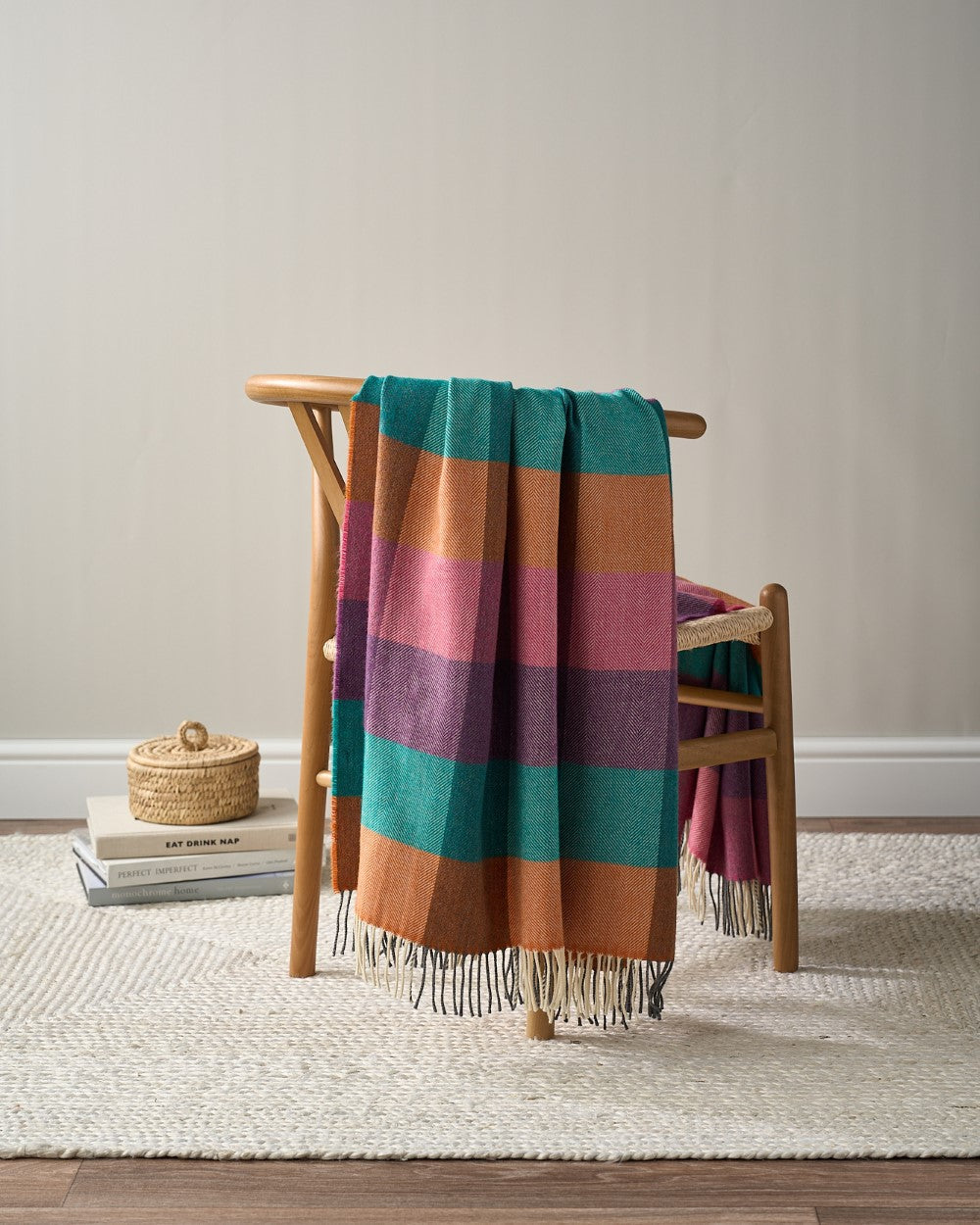 Merino Check Blanket: Hyacinth draped over a chair, showcasing a luxurious, fine texture and vibrant check pattern.