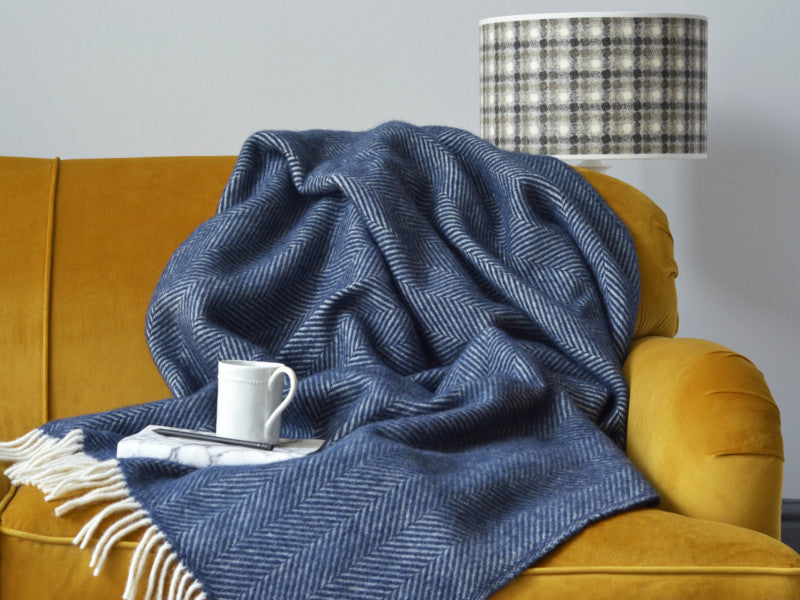 blue wool blanket on a sofa with a cup of tea
