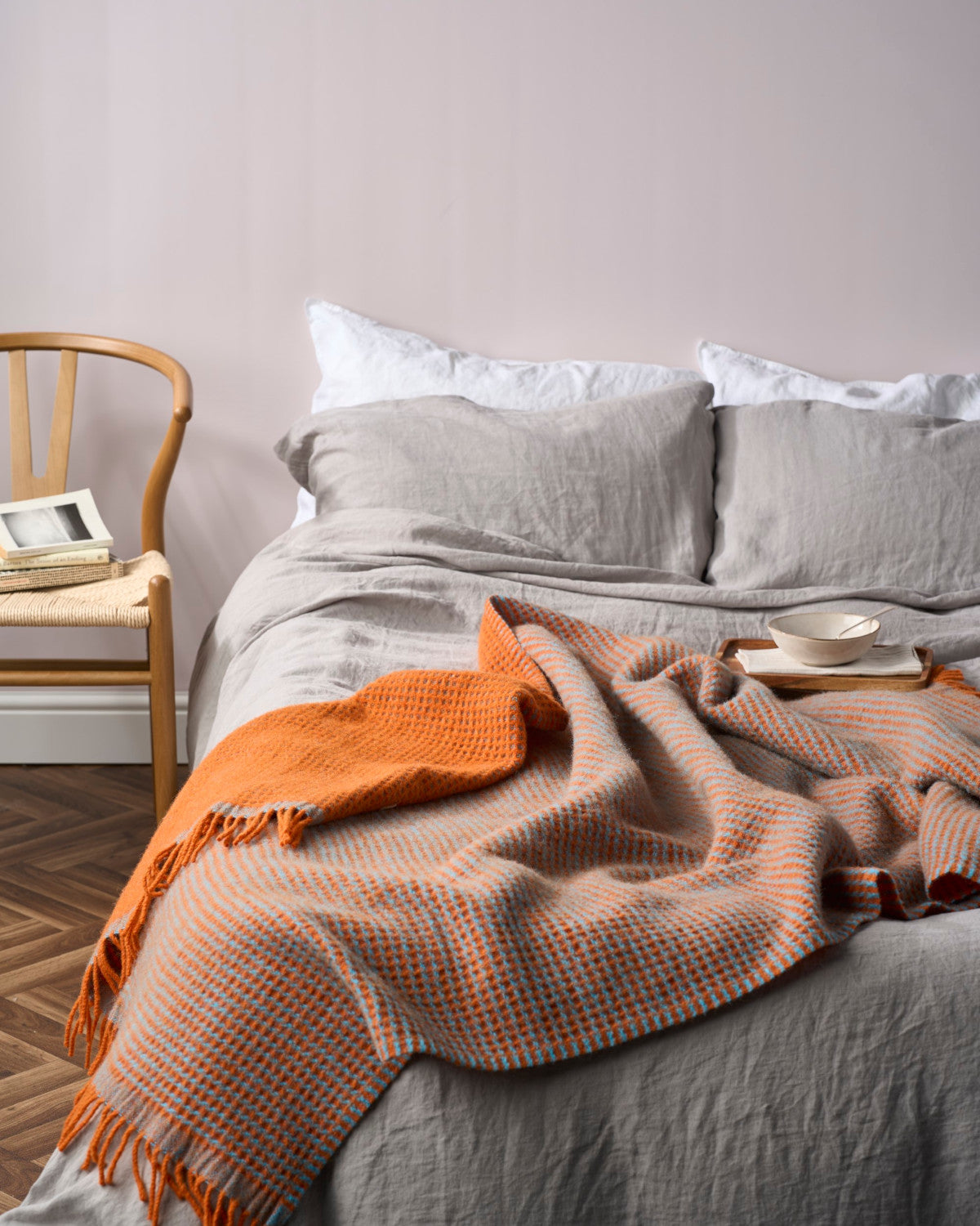 Totterdown Waffle Blanket: Beacon & Lido displayed on an indoor chair, emphasizing its textured waffle weave and reversible design crafted from pure sheep's wool.