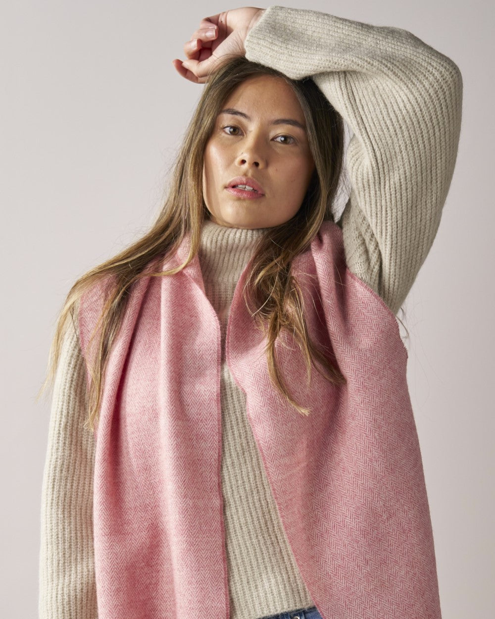 Young woman wearing a Blossom Herringbone scarf from the Scarf Gift Box, styled with a chunky knit turtleneck sweater, creating a cozy, casual look.