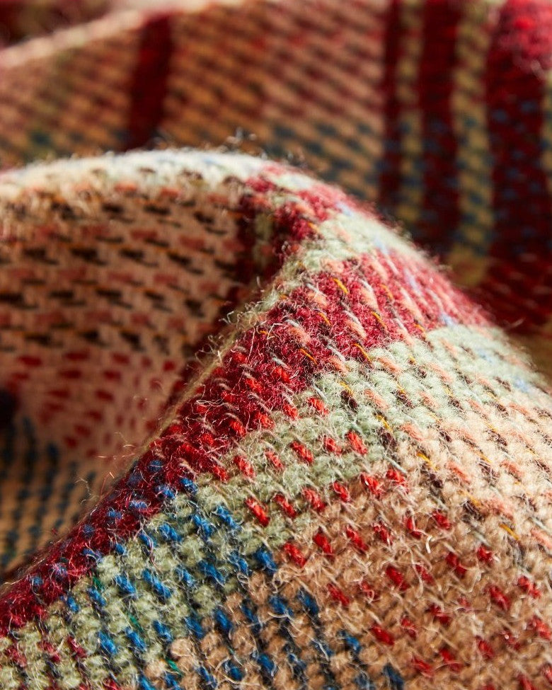 Close-up of a Dog Toy Gift Box, featuring a woolen textile with a detailed multicolored tartan pattern, showcasing its cozy and intricate weave.