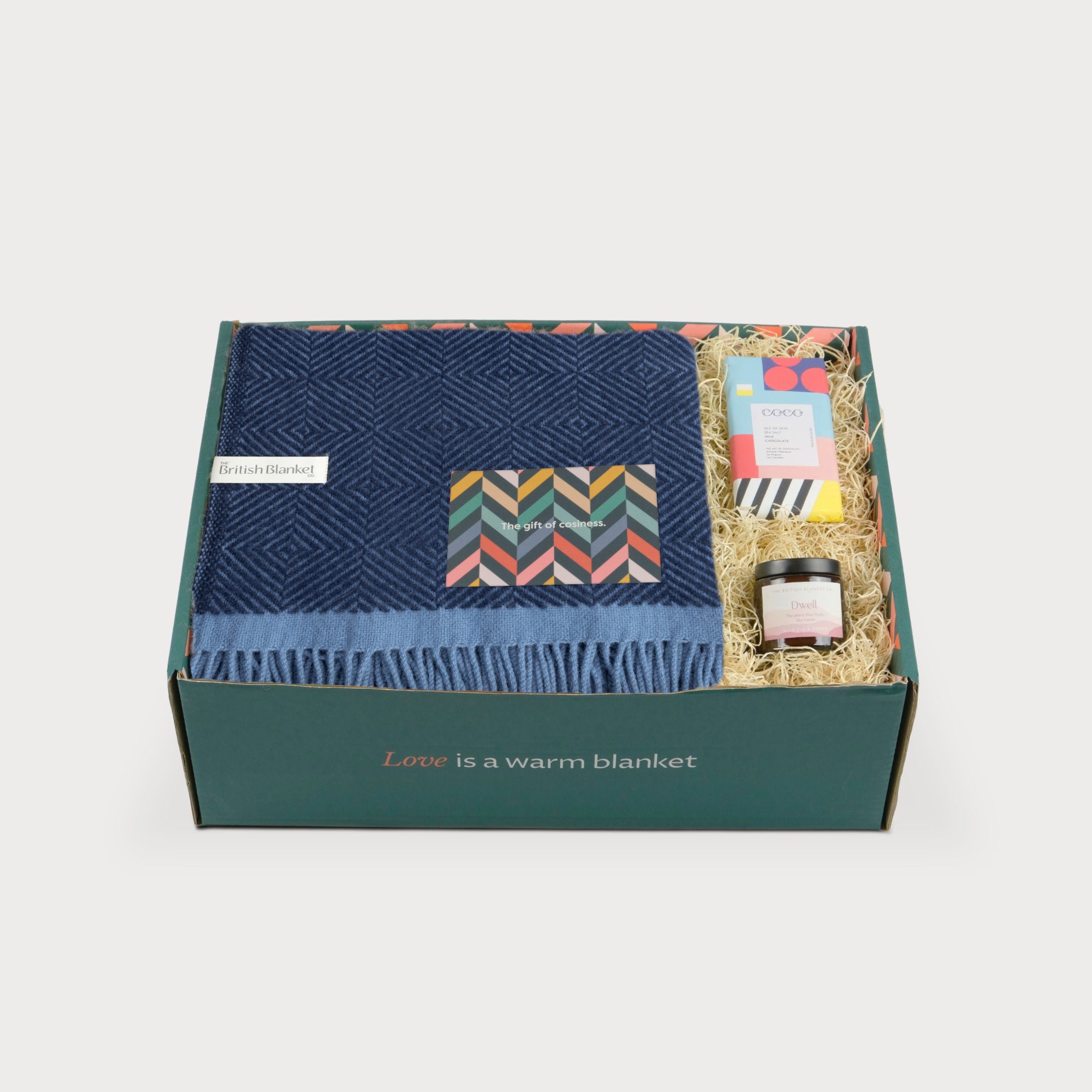 Wildweave Blanket Gift Box: Midnight & Dusk includes a navy wool throw, greeting card, artisan chocolate, and amber jar candle in a green box.
