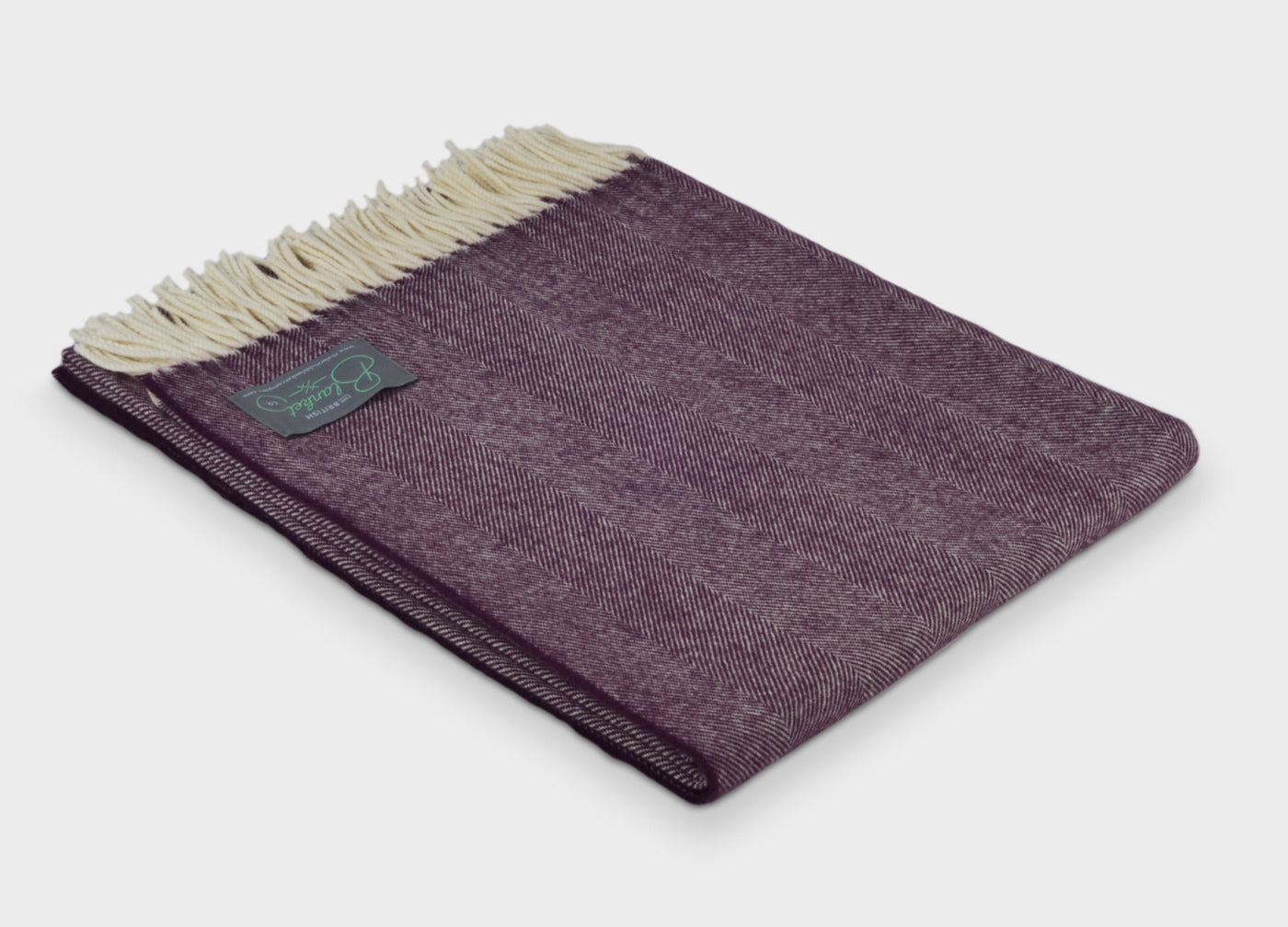 Folded purple herringbone wool throw by The British Blanket Company.
