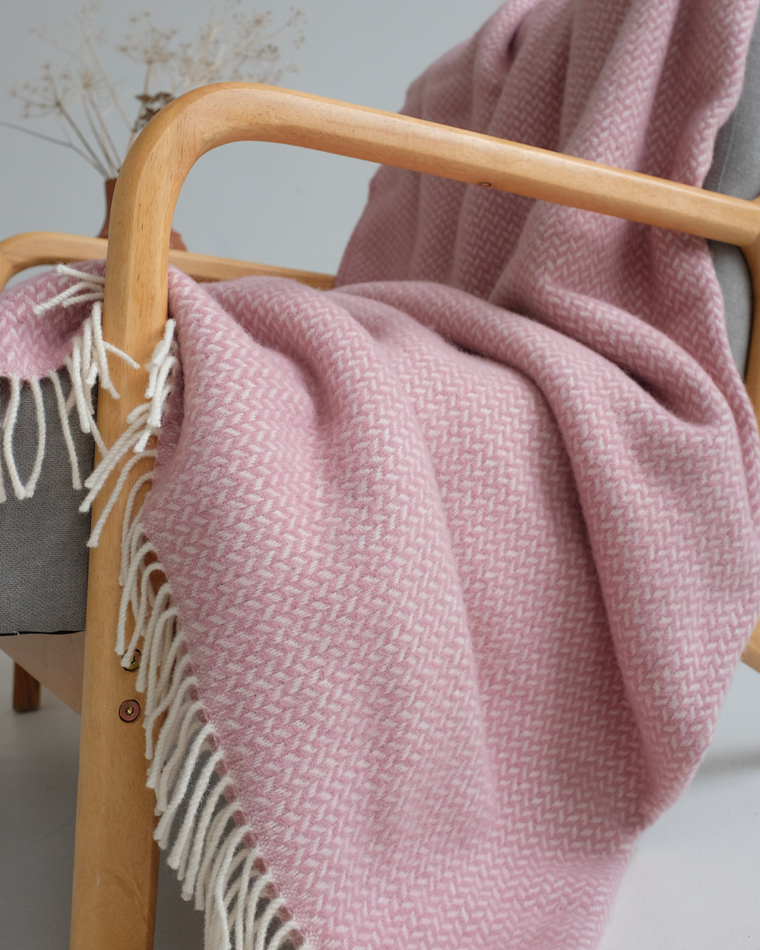 Closeup of pink herringbone wool throw on lounge chair.