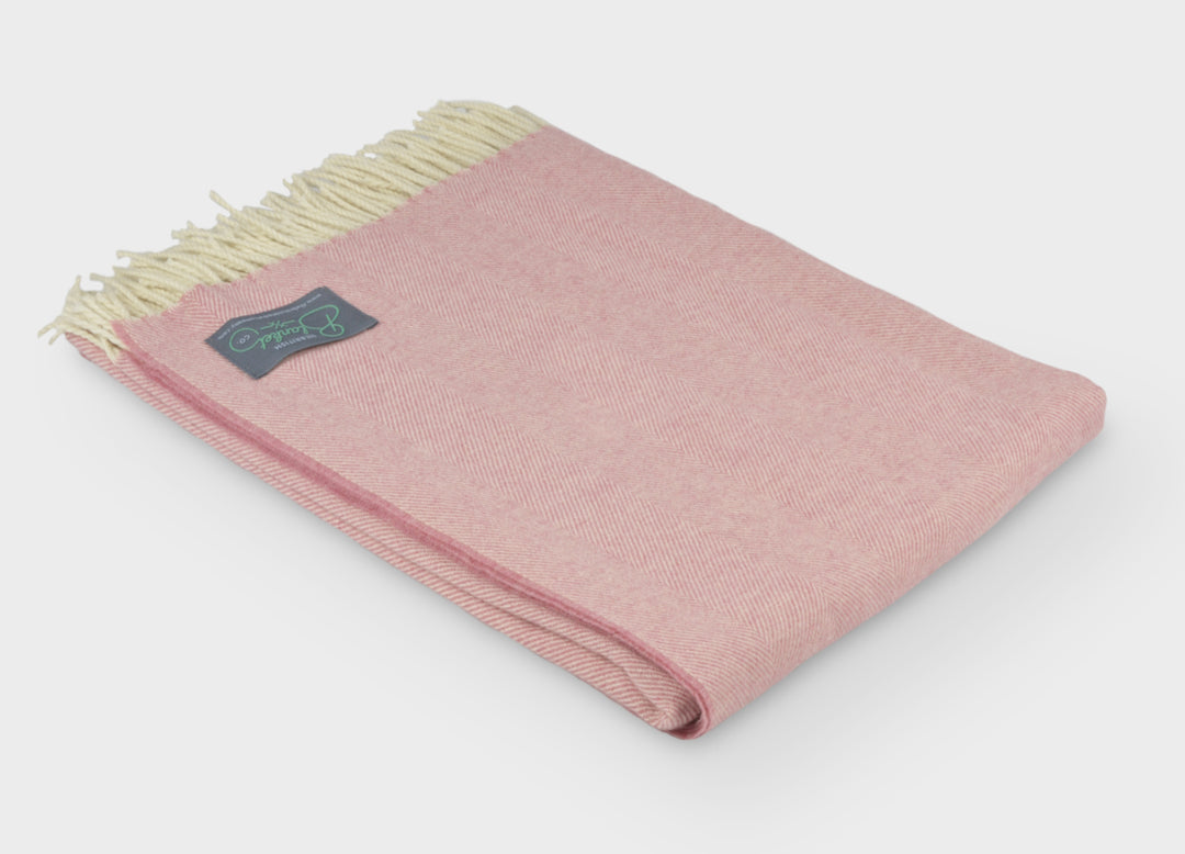 A folded pink merino herringbone wool throw by The British Blanket Company.