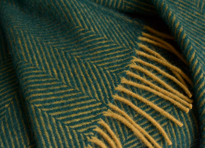Closeup of an extra large green and yellow herringbone wool throw