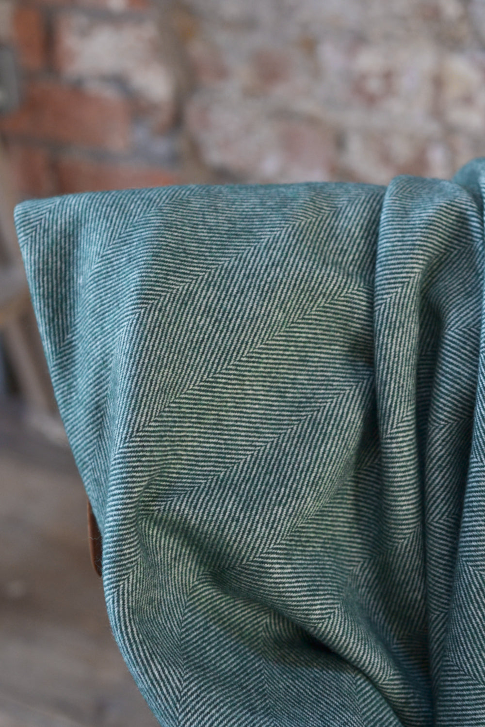 Closeup of green herringbone wool throw by The British Blanket Company.
