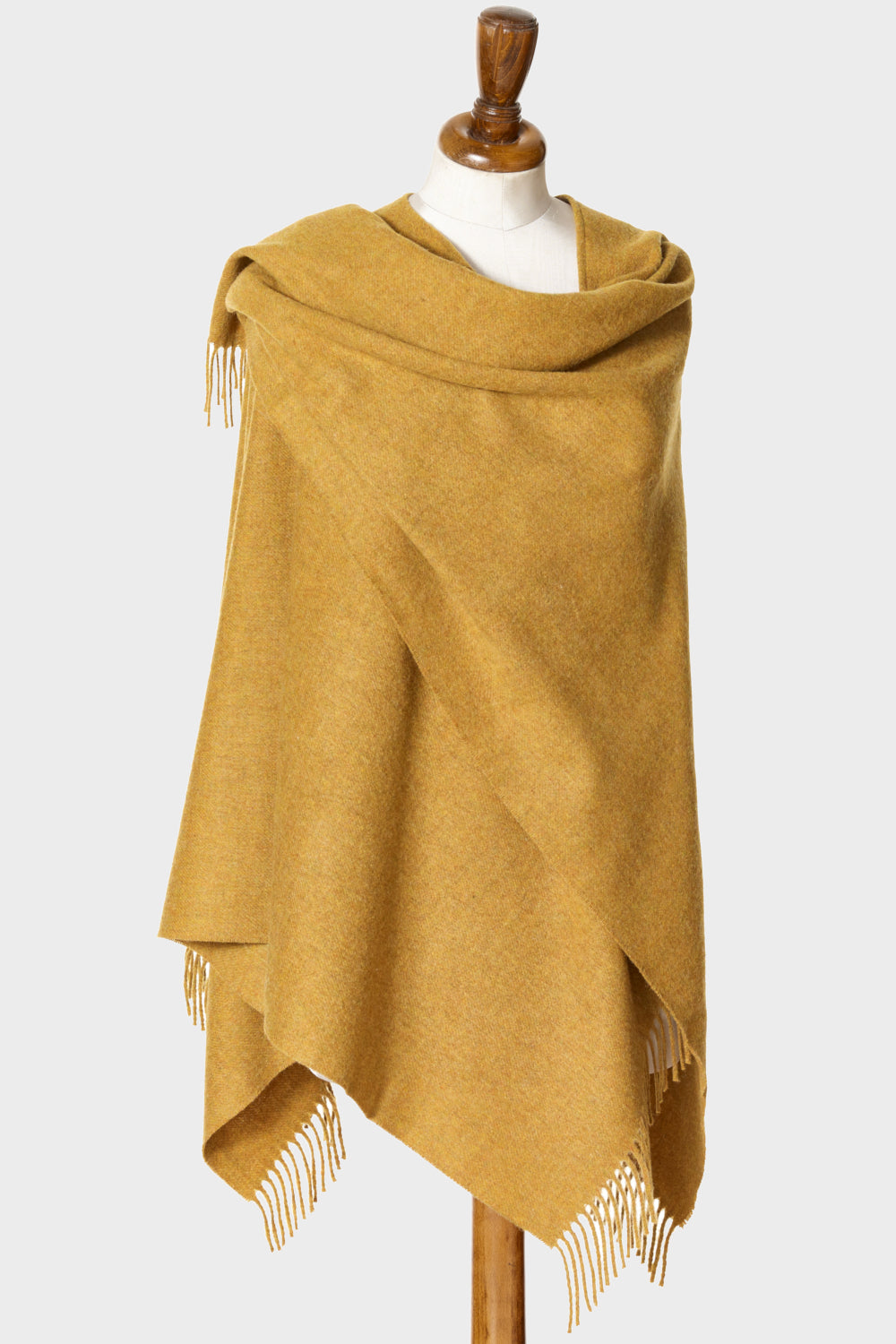 Wearable gold wool blanket wrap on a mannequin.