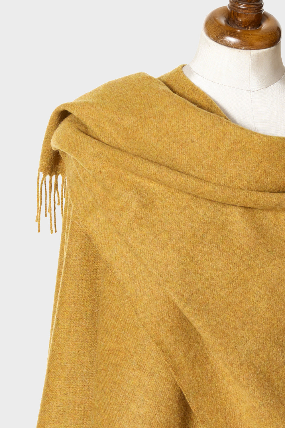 Wearable gold wool blanket wrap wrapped on a mannequin.