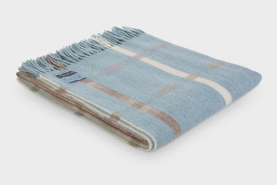 Folded blue Garden Flowers wool throw by The British Blanket Company