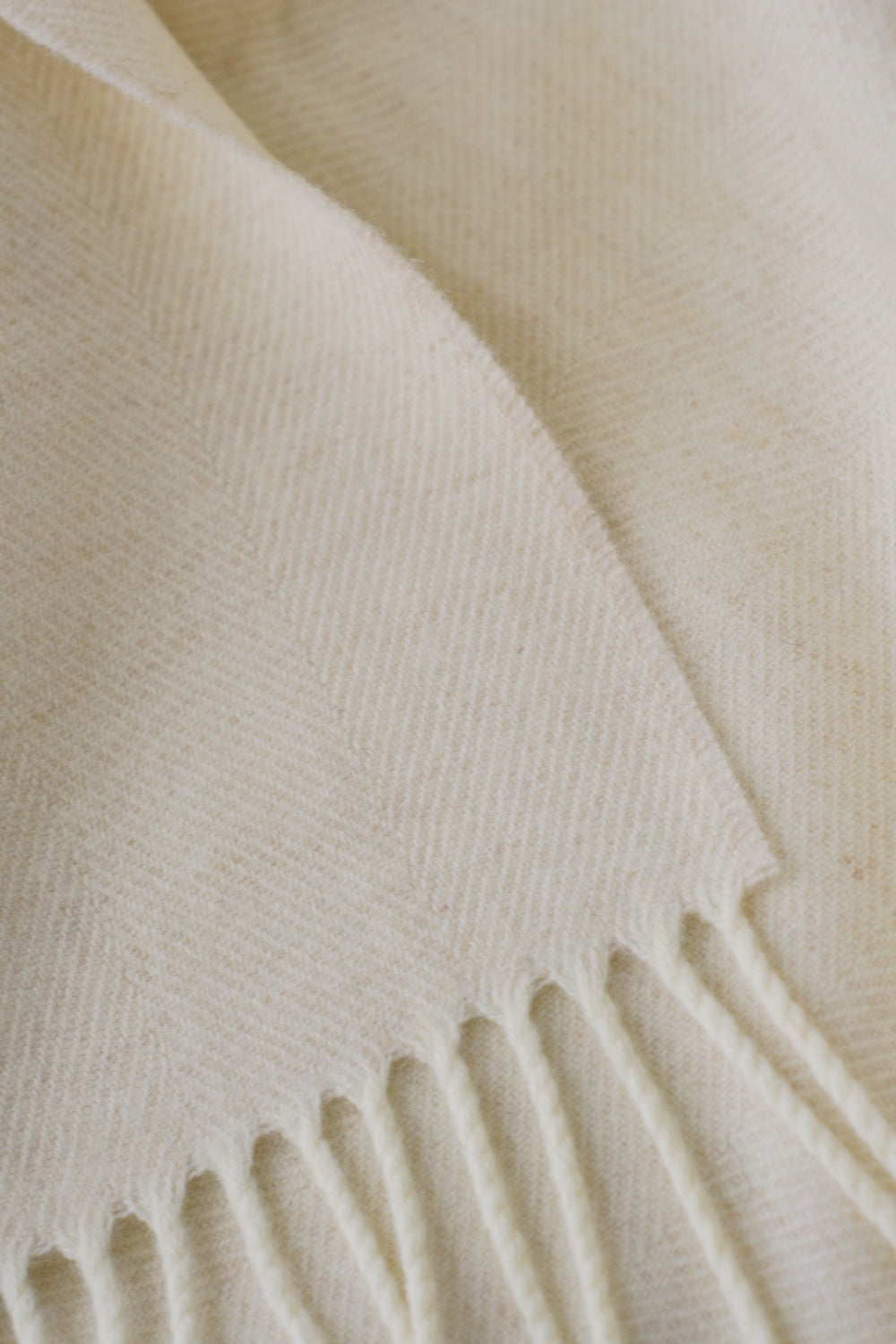 Closeup of cream merino herringbone wool throw by The British Blanket Company.