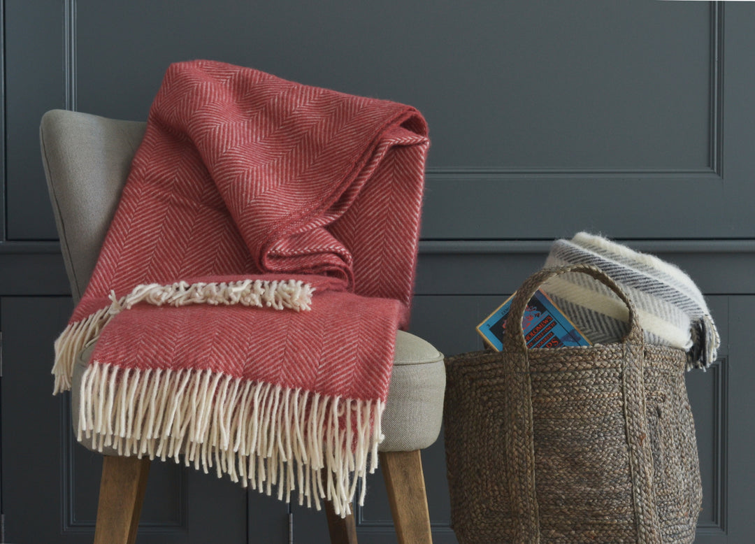 Large red herringbone wool blanket draped over a lounge chair