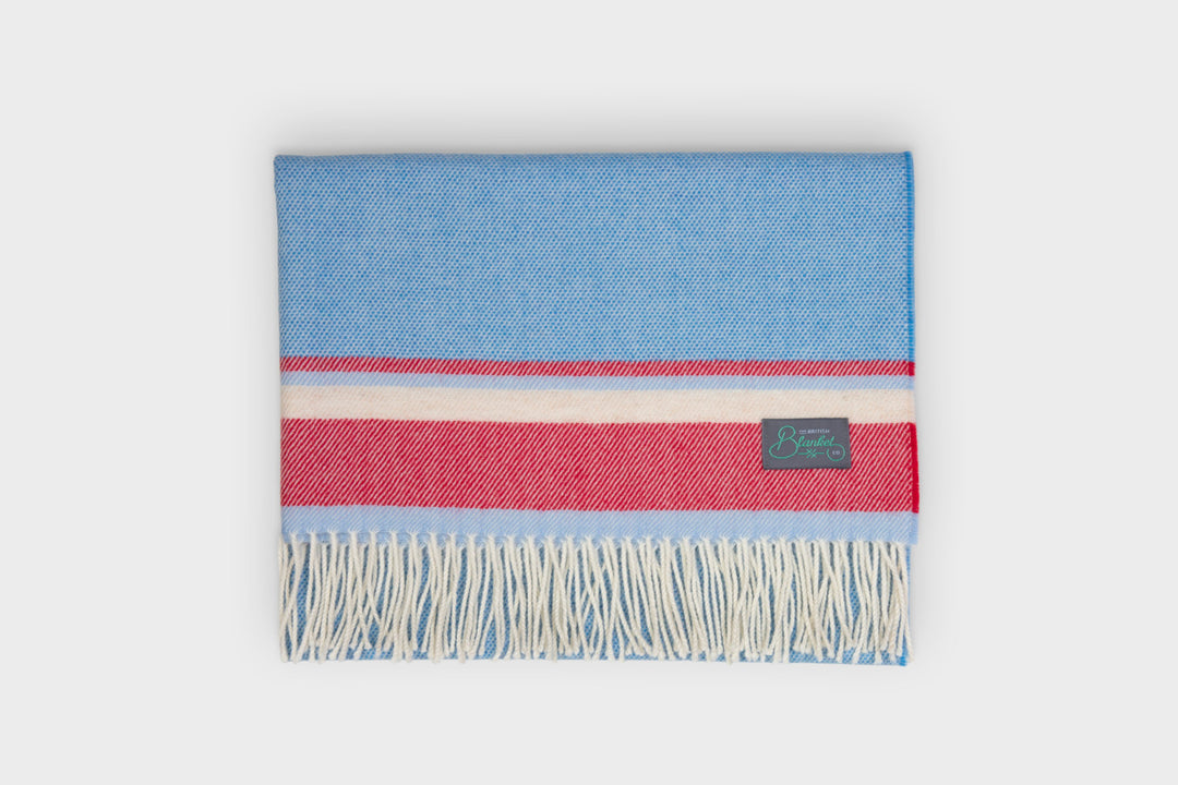 A folded blue and red merino wool baby blanket by The British Blanket Company