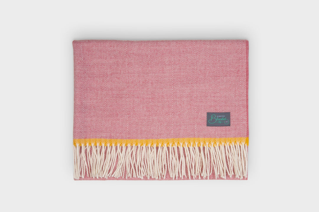 Folded pink merino lambswool baby blanket by The British Blanket Company
