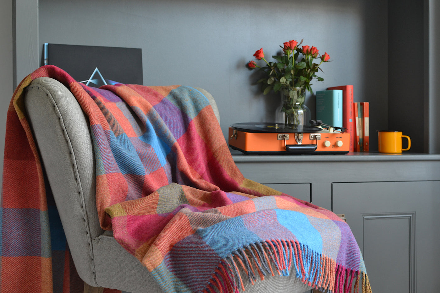 Large multicoloured check wool blanket draped over a lounge chair