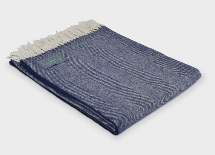 Folded blue merino herringbone wool throw by The British Blanket Company