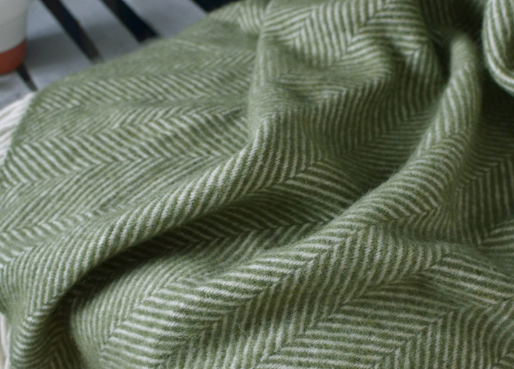 Closeup of a green herringbone wool throw