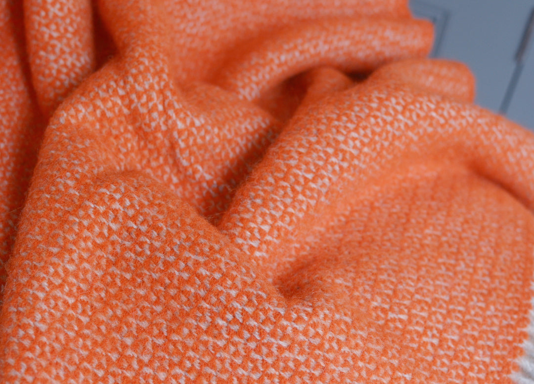 Closeup of orange and grey windmill wool blanket