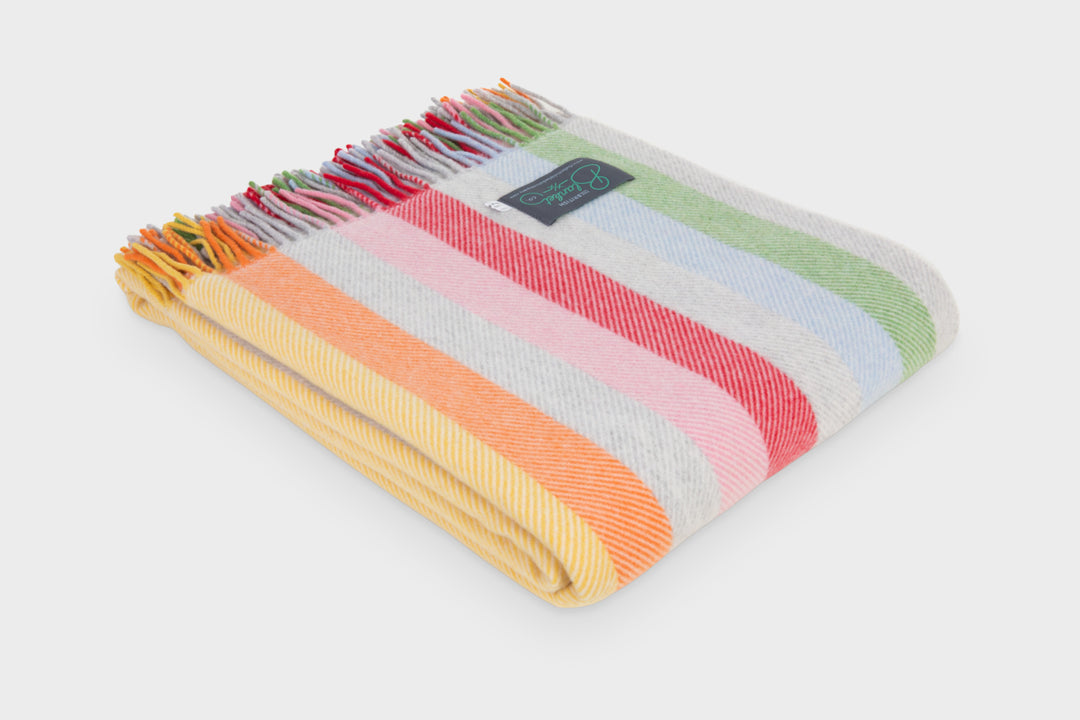 Folded rainbow stripe merino herringbone wool throw by The British Blanket Company