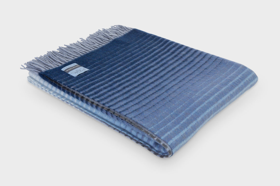 Folded blue ombre merino wool throw by The British Blanket Company