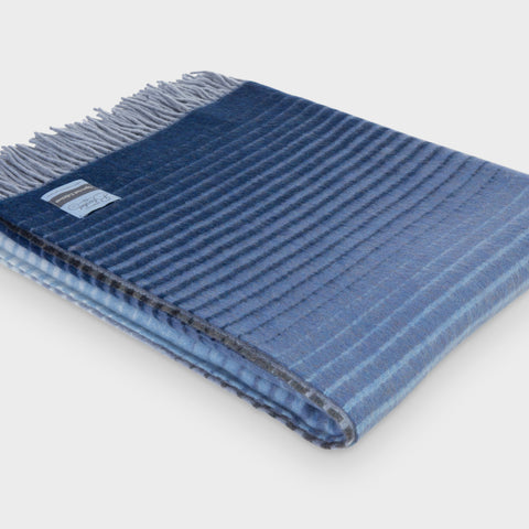 Folded blue ombre merino wool throw by The British Blanket Company