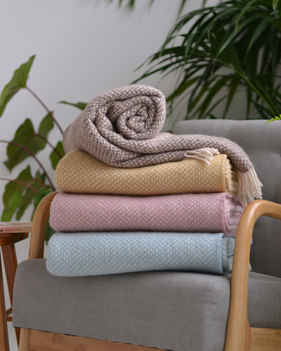 A stack of wool blankets on a grey lounge chair