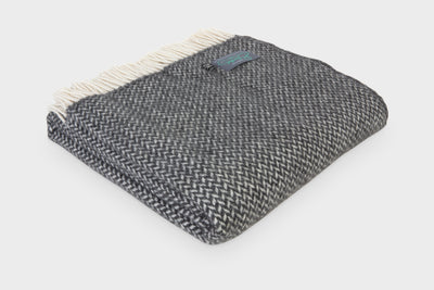 A folded grey herringbone wool throw by The British Blanket Company. 