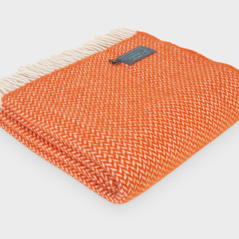 Folded large orange herringbone wool throw by The British Blanket Company