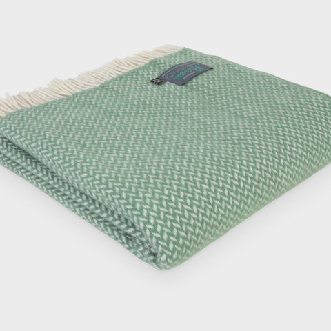 Folded XL green herringbone wool throw by The British Blanket Company