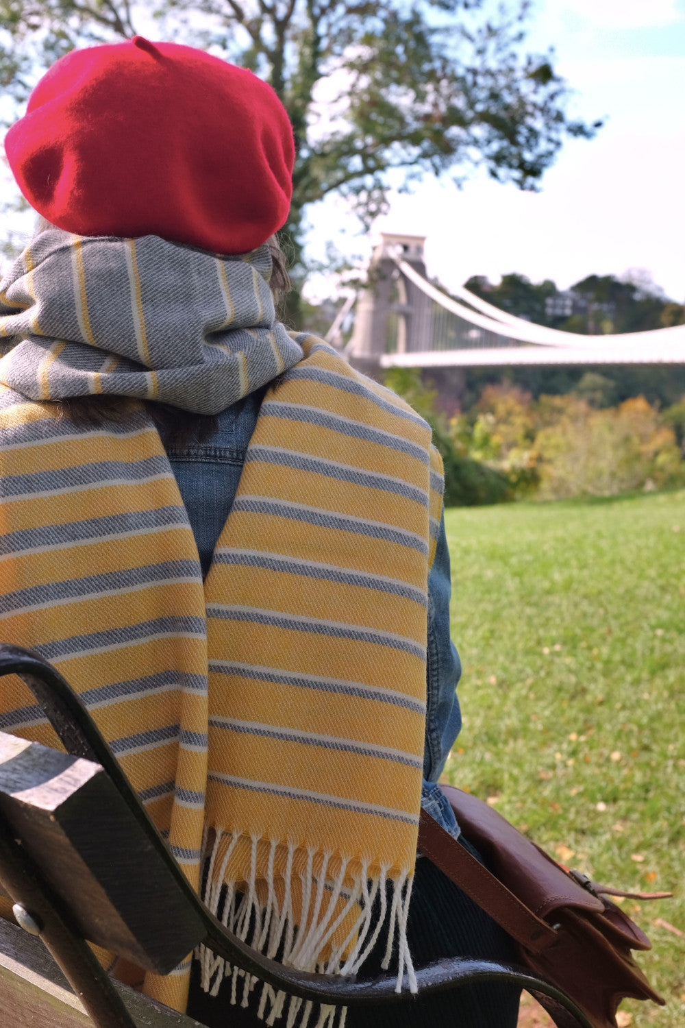 An oversized yellow and grey blanket scarf wrapped around a woman's neck 