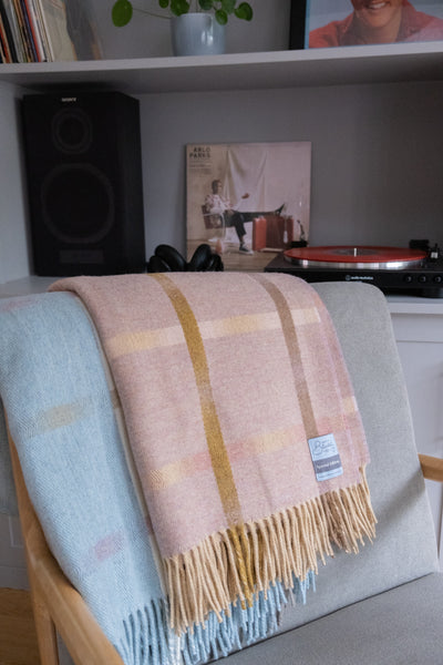 Large merino lambswool throws draped over a lounge chair