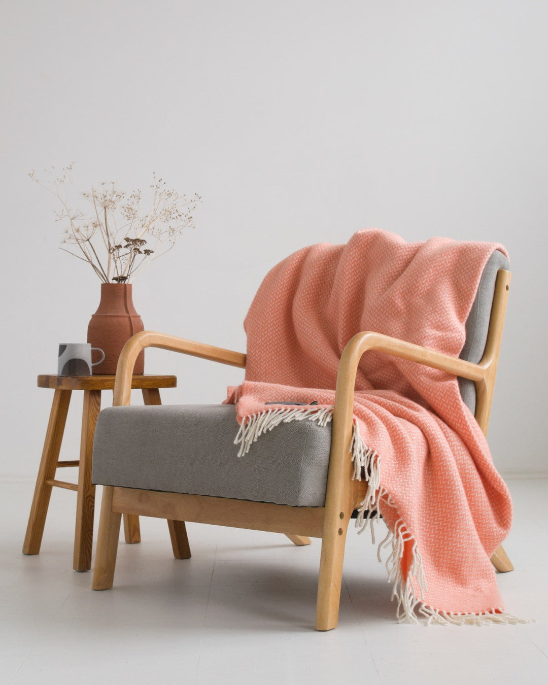 Extra large pink herringbone wool blanket draped over a lounge chair