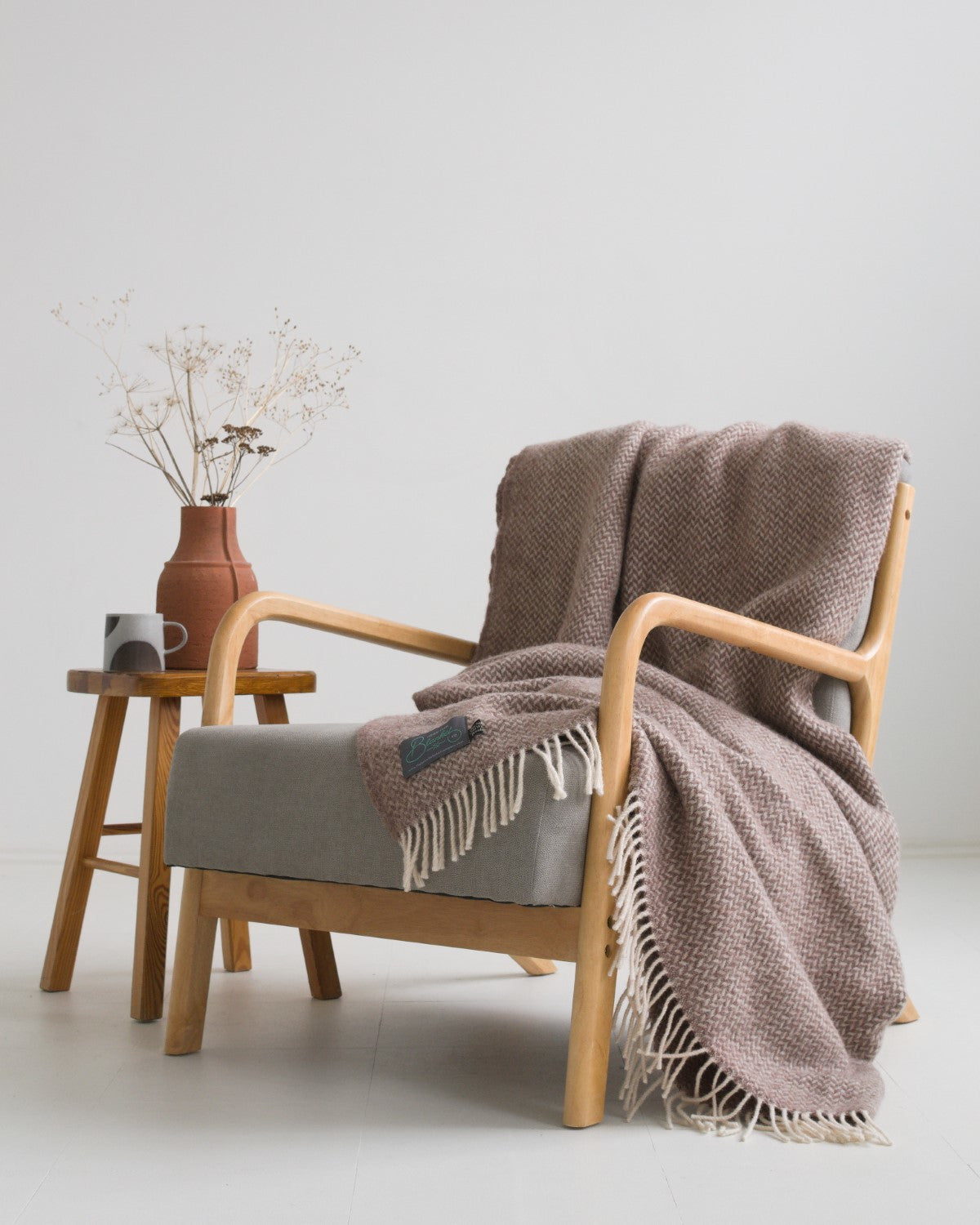 Large brown herringbone wool blanket draped over a lounge chair