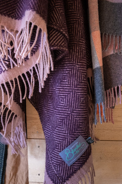 Closeup of a hanging purple wildweave wool throw by The British Blanket Company