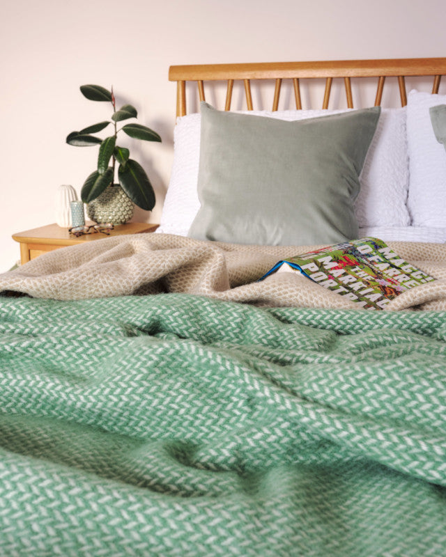 fresh and light bedroom decor with bed styled with sage green signature herringbone king size wool throw blanket by The British Blanket Company online shop
