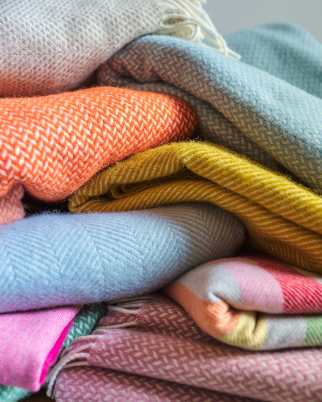 stack of brightly coloured wool throw blankets by The British Blanket Company online shop